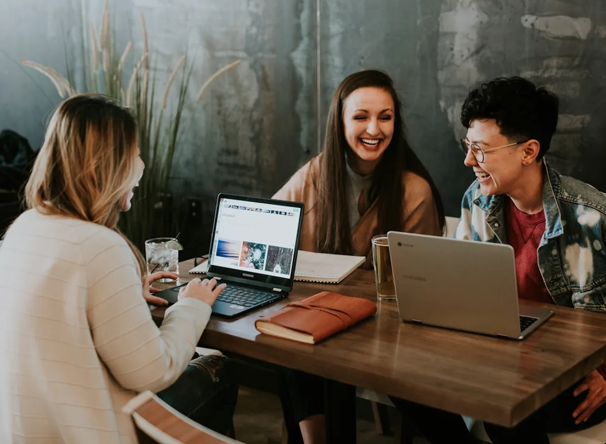 Three colleagues working together over laptops